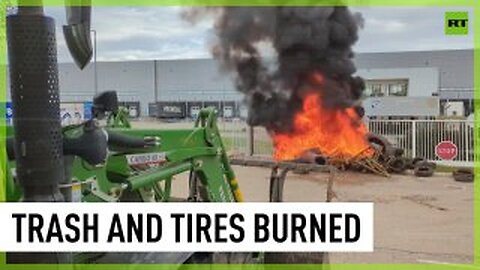 Farmers burn tires and trash outside govt building in southern France