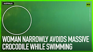 Woman narrowly avoids massive crocodile while swimming